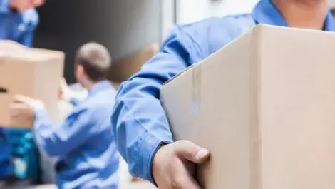 People carrying moving boxes out of a storage truck.