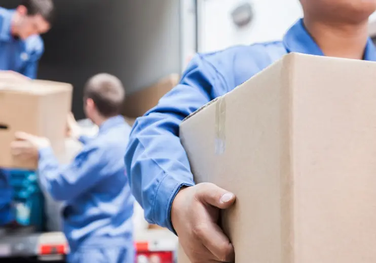 People carrying moving boxes out of a storage truck.