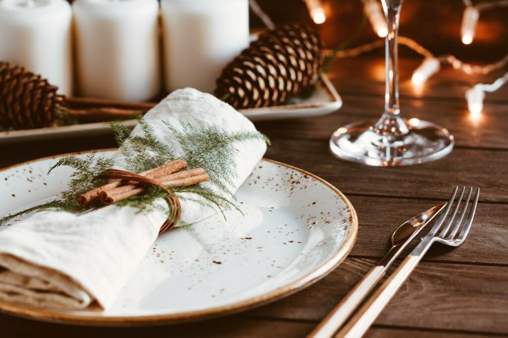 Table festively decorated with a plate, napkins, and utensils for an upcoming holiday party.