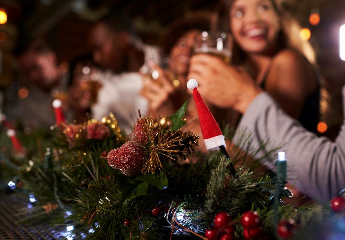 A group of people sitting at a decorated table enjoying a holiday party.