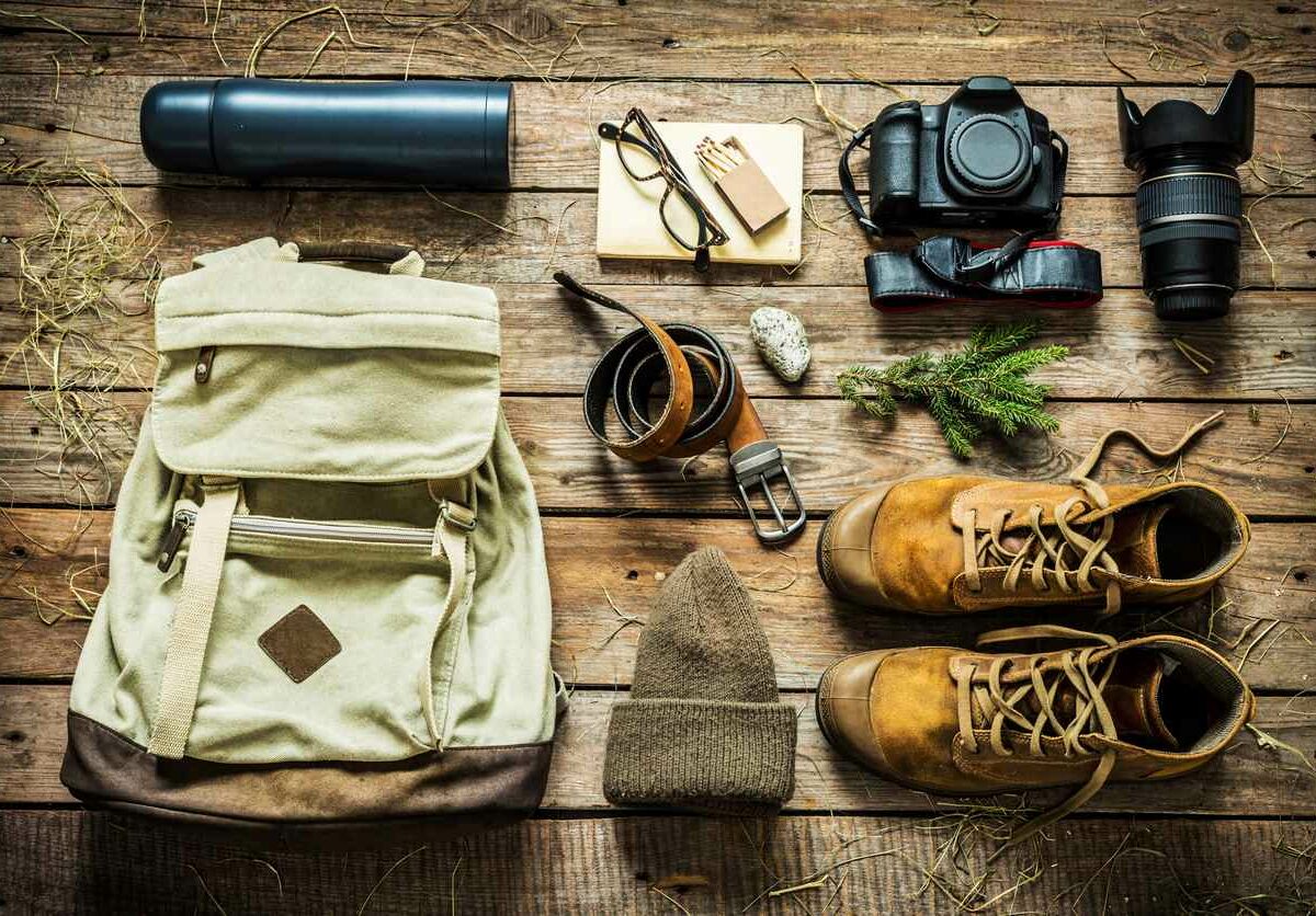 Overhead shot of outdoor gear laid on a wooden table.