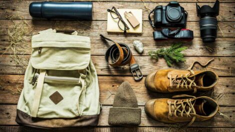 Overhead shot of outdoor gear laid on a wooden table.