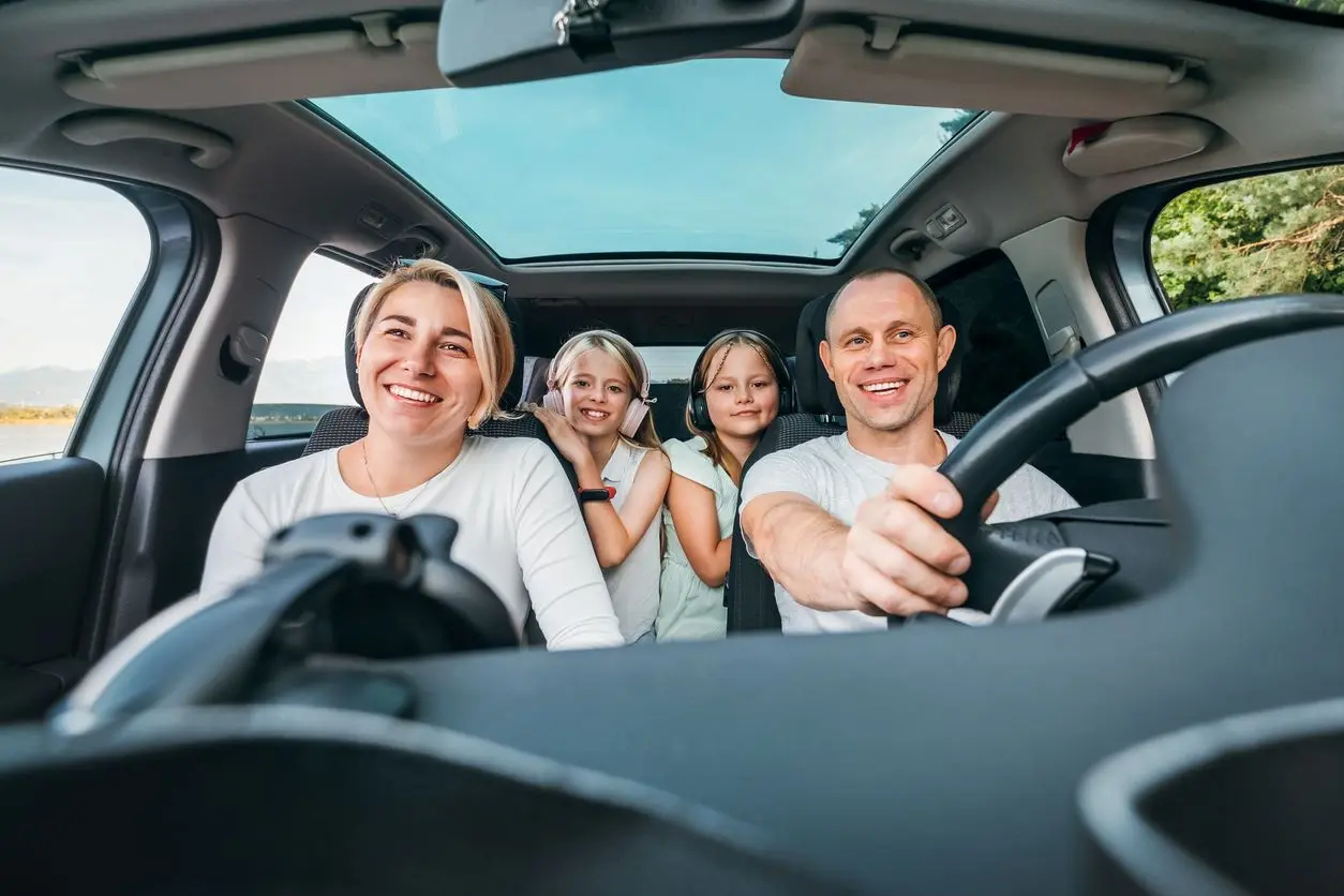 A happy young family taking a trip in the car.