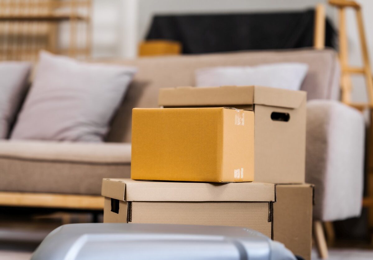 A group of cardboard boxes is stacked on top of each other in a living room and is ready to be stored.