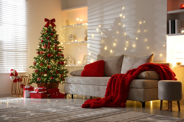 A tidy living room filled with holiday decorations, including a Christmas tree and string lights.