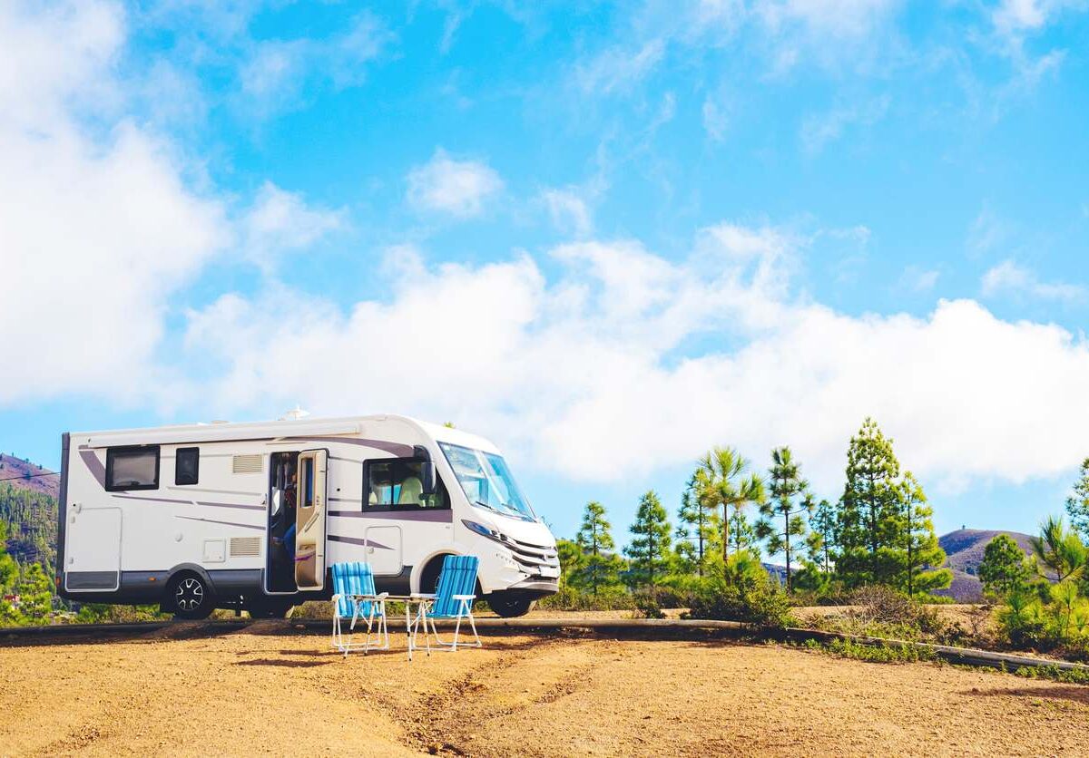 A nice RV parked on the top of a hill.