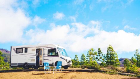 A nice RV parked on the top of a hill.